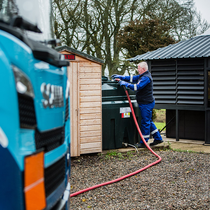 A tanker driver from Carnegie Fuels filling up a home heating oil tank in Scotland